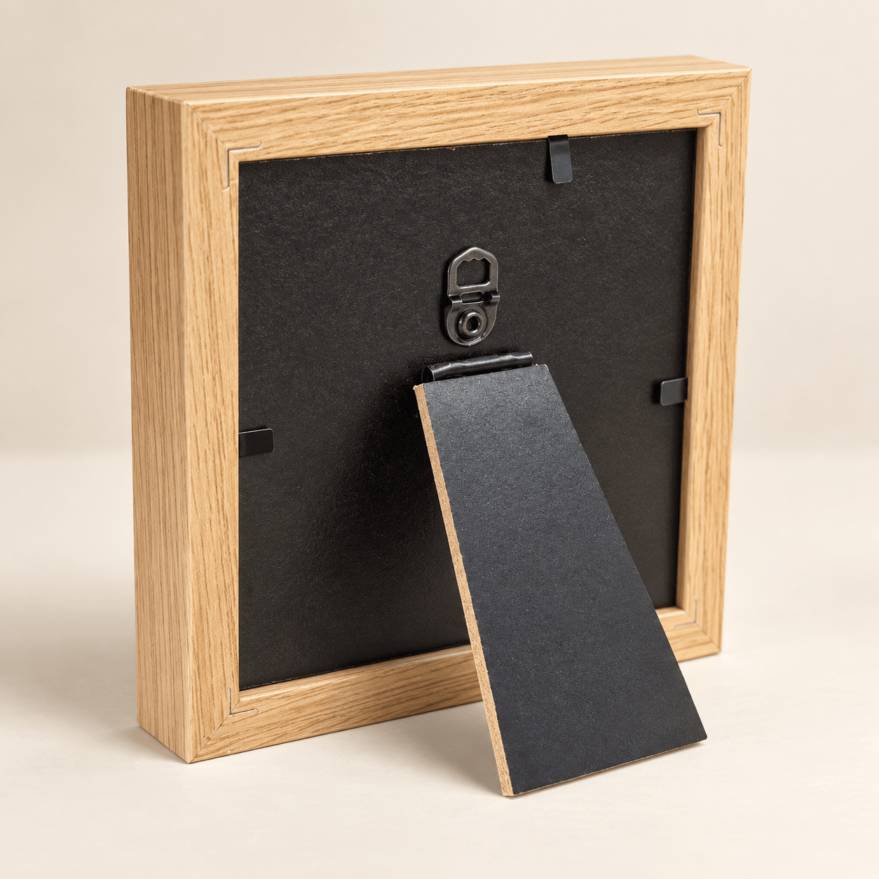Rear view of the square frame showing its hanging hook, backing retainers, and open tabletop easel
